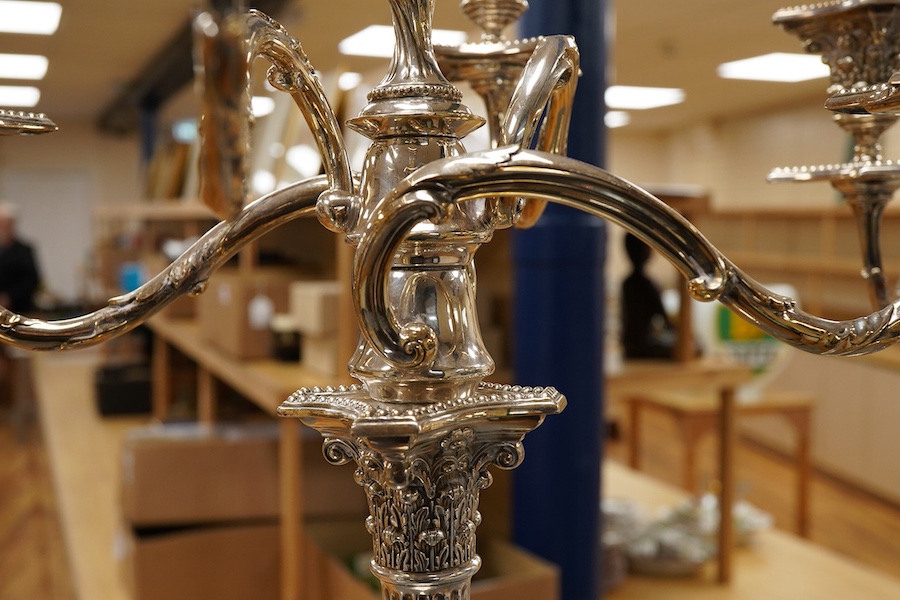 A garniture of 19th century silver plated Corinthian column candelabra, comprising a pair of two branch, three light candelabra and matching four branch, five light candelabrum, with detachable acanthus leaf capped scrol